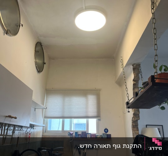מנורה מותקנת בתקרה במטבח עם כלים על השיש